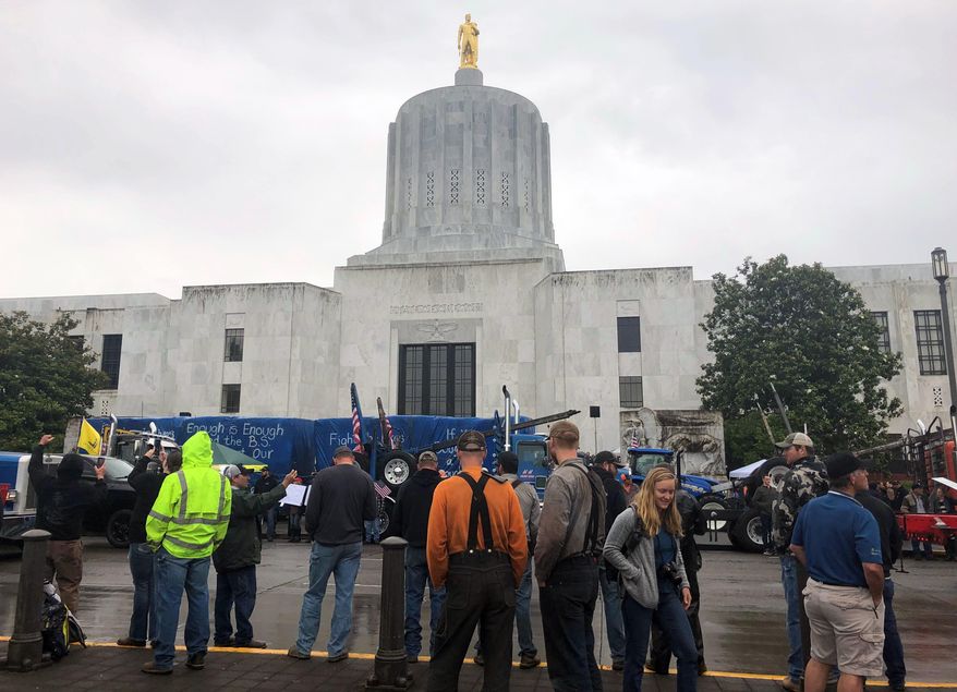 Protesters converge outside the Oregon state Capitol in Salem, Ore. on Thursday, June 27, 2019. Truckers, loggers and farmers say they support the eleven Republican senators who walked out over a week ago to avoid a vote on climate legislation. (AP Photo/Sarah Zimmerman)