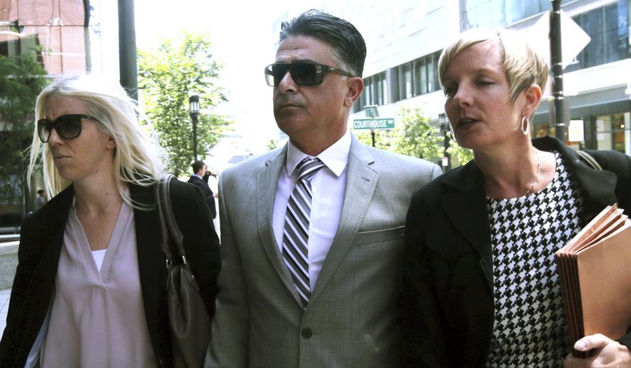 Former USC women's soccer coach Ali Khosroshahin, center, arrives at federal court Thursday, June 27, 2019, in Boston, where he is scheduled to plead guilty to charges in a nationwide college admissions bribery scandal. (AP Photo/Charles Krupa)