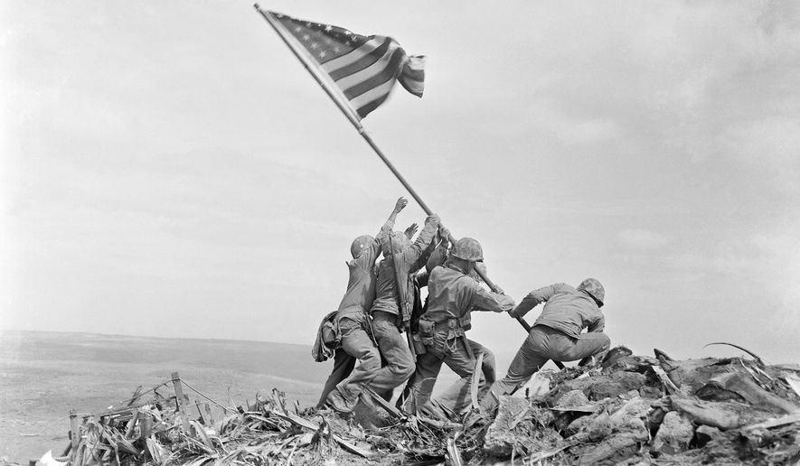 In this Feb. 23, 1945, file photo, U.S. Marines of the 28th Regiment, 5th Division, raise the American flag atop Mount Suribachi, Iwo Jima, Japan. (AP Photo/Joe Rosenthal, File)