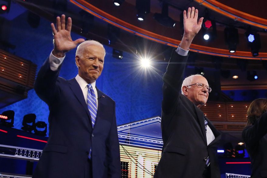 Democratic presidential candidates former vice president Joe Biden, left, and Sen. Bernie Sanders, I-Vt., wave before the start of a Democratic primary debate hosted by NBC News at the Adrienne Arsht Center for the Performing Arts, Thursday, June 27, 2019, in Miami. (AP Photo/Brynn Anderson)