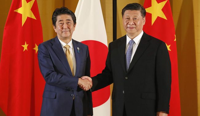Chinese President Xi Jinping, right, and Japanese Prime Minister Shinzo Abe shake hands at the start of their talks at a hotel in Osaka, western Japan, Thursday, June 27, 2019, ahead of the G-20 Summit. (Kimimasa Mayama/Pool Photo via AP)