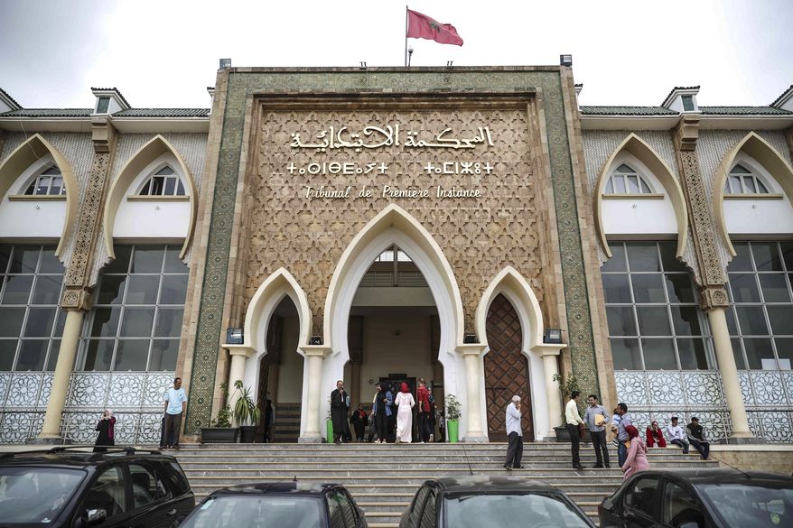 People stand outside a court during a trial for suspects charged with killing of two Scandinavian tourists in Morocco's Atlas Mountains in Sale, near Rabat, Morocco, Thursday, June 27, 2019. (AP Photo/Mosa'ab Elshamy)