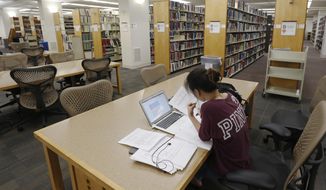 In this June 20, 2019 file photo, a student works in the library at Virginia Commonwealth University in Richmond, Va.  (AP Photo/Steve Helber)  **FILE**
