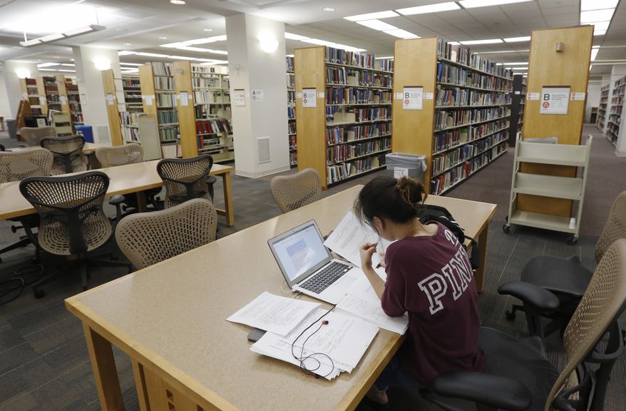 In this June 20, 2019 file photo, a student works in the library at Virginia Commonwealth University in Richmond, Va.  (AP Photo/Steve Helber)  **FILE**