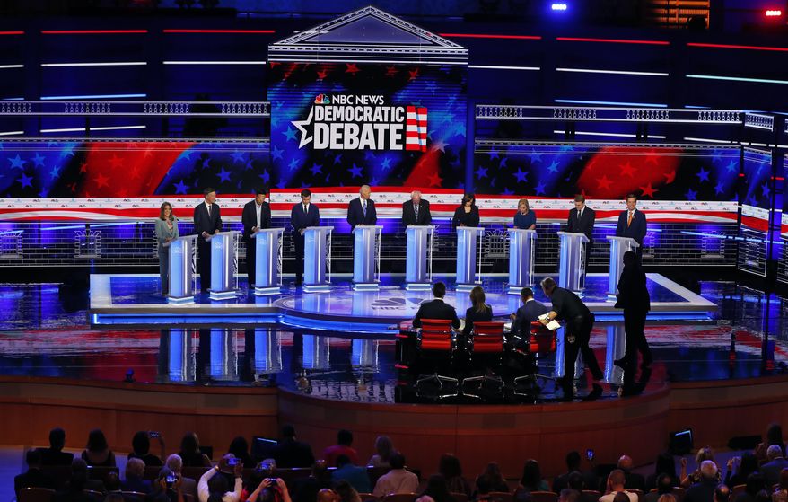 CORRECTS BENNET'S TITLE TO SENATOR, INSTEAD OF FORMER SENATOR - Democratic presidential candidates, author Marianne Williamson, former Colorado Gov. John Hickenlooper, entrepreneur Andrew Yang, South Bend Mayor Pete Buttigieg, former Vice President Joe Biden, Sen. Bernie Sanders, I-Vt., Sen. Kamala Harris, D-Calif., Sen. Kirsten Gillibrand, D-N.Y., Colorado Sen. Michael Bennet, and Rep. Eric Swalwell, D-Calif., listen to a question during a Democratic primary debate hosted by NBC News at the Adrienne Arsht Center for the Performing Arts, Thursday, June 27, 2019, in Miami. (AP Photo/Wilfredo Lee)