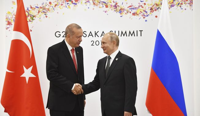 Russian President Vladimir Putin, right, and Turkish President Recep Tayyip Erdogan shake hands during their bilateral meeting on the sidelines of the G-20 summit in Osaka Saturday, June 29, 2019. (Yuri Kadobnov/Pool Photo via AP)