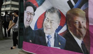 A banner shows images, from left, of North Korean leader Kim Jong-un, South Korean President Moon Jae-in and U.S. President Donald Trump, displayed by protesters who demand the peace on Korean peninsula, ahead of U.S. President Donald Trump&#39;s scheduled visit near U.S. Embassy in Seoul, South Korea, Friday, June 28, 2019. (AP Photo/Lee Jin-man)
