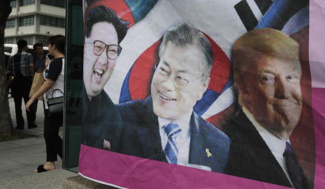 A banner shows images, from left, of North Korean leader Kim Jong-un, South Korean President Moon Jae-in and U.S. President Donald Trump, displayed by protesters who demand the peace on Korean peninsula, ahead of U.S. President Donald Trump&#x27;s scheduled visit near U.S. Embassy in Seoul, South Korea, Friday, June 28, 2019. (AP Photo/Lee Jin-man)
