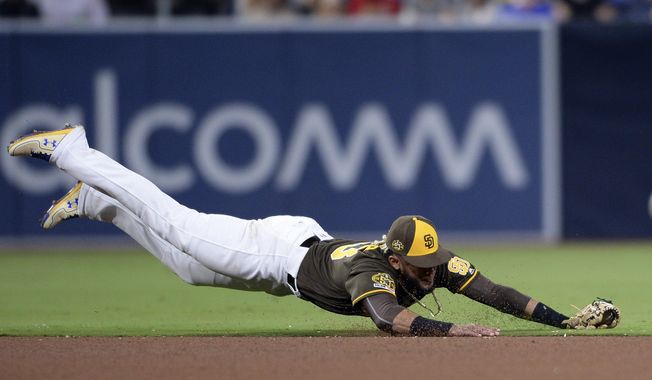 San Diego Padres shortstop Fernando Tatis Jr. dives for a ground ball single hit by St. Louis Cardinals&#x27; Michael Wacha during the fourth inning of a baseball game Friday, June 28, 2019, in San Diego. (AP Photo/Orlando Ramirez)