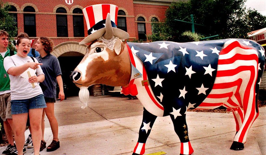 FILE - In this Aug. 13, 1999 file photo, fairgoers enjoy "Uncle Sam," one of several Cows on Parade being exhibited during the 147th Illinois State Fair in Springfield. A herd of fiberglass cows will be returning to Chicago’s Michigan Avenue to mark the 20-year-anniversary of a display of brightly painted bovines captured the attention of the country and inspired other cities to line their streets with their own statues of everything from lobsters to pigs to salmon. For the entire month of July, some 20 of these cows on display it is calling “Cows Come Home” to commemorate “Cows On Parade,” a 1999 public art exhibit consisting of well over 300 of the fiberglass critters sporting everything from baseball hats to Hawaii shorts to ladybug wings (AP Photo/Seth Perlman)
