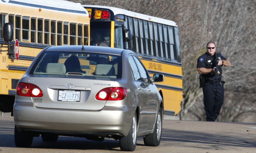 In this Jan. 3, 2014 file photograph, a police officer forces a driver to back away from a practice rescue of students at Clinton High School in Clinton, Miss., during an active shooter drill. Several new laws are taking effect Monday, July 1, 2019 in Mississippi, including a requirement that public schools are required to have active-shooter drills. (AP Photo/Rogelio V. Solis, File)