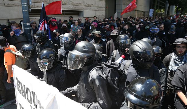In this file photo, protesters including Rose City Antifa, are shown in downtown Portland, Ore., Saturday, June 29, 2019. (Dave Killen/The Oregonian via AP) ** FILE **