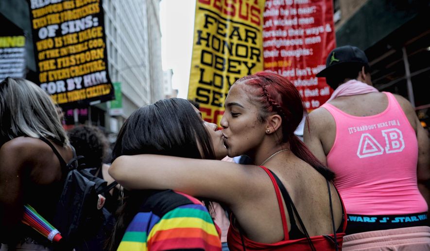 Parade-goers kiss in front of a counter-protest to the Gay Pride parade in New York on Sunday, June 30, 2019. (AP Photo/Wong Maye-E) ** FILE **