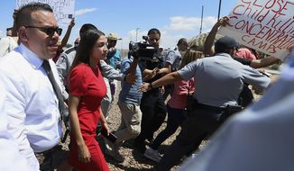 U.S. Rep. Alexandria Ocasio-Cortez, D-New York, is escorted back to her vehicle after she speaks at the Border Patrol station in Clint, Texas, about what she saw at area border facilities Monday, July 1, 2019. (Briana Sanchez/El Paso Times via AP)