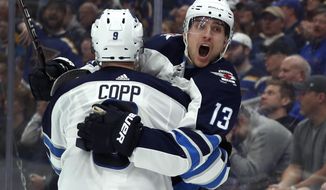 FILE - In this April 14, 2019, file photo, Winnipeg Jets&#39; Brandon Tanev (13) is congratulated by teammate Andrew Copp after scoring during the third period in Game 3 of an NHL first-round hockey playoff series against the St. Louis Blues,  in St. Louis. In Pittsburgh, the Penguins used some of their wiggle room under the salary cap created by trading Phil Kessel to Arizona to land Winnipeg forward Brandon Tanev during the opening day of NHL free agency. Tanev signed a six-year deal with an average annual value of $3.5 million. The 27-year-old is coming off a career season with the Jets. (AP Photo/Jeff Roberson, File)