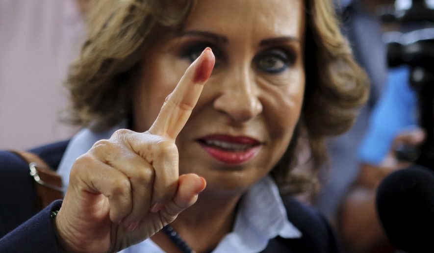 FILE - In this June 16, 2019 file photo, Sandra Torres, presidential candidate of the National Unity of Hope party, UNE, shows her ink stained finger to the press after casting her vote during general elections in Guatemala City. Supreme Electoral Tribunal officials said Monday, July 1, at a news conference that Torres and Dr. Alejandro Giammattei will face each other in the Aug. 11 second round to decide the presidency. (AP Photo/Oliver de Ros, File)