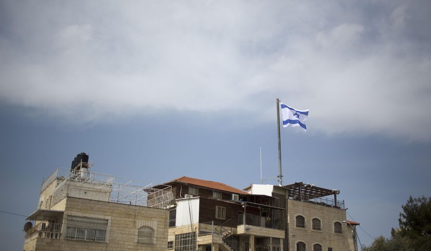In this March 13, 2019 photo, an Israeli flag flies on a building in east Jerusalem&#39;s Mount of Olives. The Falic family, owners of the ubiquitous chain of Duty Free America shops, fund a generous, and sometimes controversial, philanthropic empire in Israel that stretches deep into the West Bank. The family supports many mainstream causes as well as far right causes considered extreme even in Israel. (AP Photo/Ariel Schalit)
