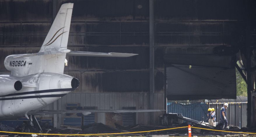 National Transportation Safety Board and FBI investigators inspect a hangar at Addison Airport in Addison, Texas, Monday, July 1, 2019, the day after a twin-engine plane crashed into the building killing all ten people on board. (Shaban Athuman/The Dallas Morning News via AP)