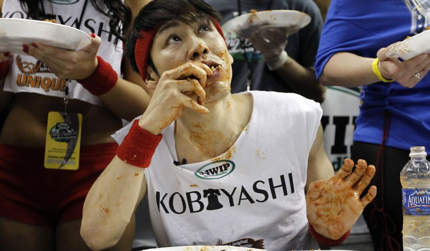 This Feb. 3, 2012, photo shows Japanese competitive eater Takeru Kobayashi eating chicken wings during SportsRadio WIP's Wing Bowl 2012 eating contest in Philadelphia. Kobayashi won by eating 337 wings. Kobayashi is the subject of an ESPN documentary, "The Good, The Bad, The Hungry," airing on Tuesday, July 2, 2019. (AP Photo/Alex Brandon) **FILE**