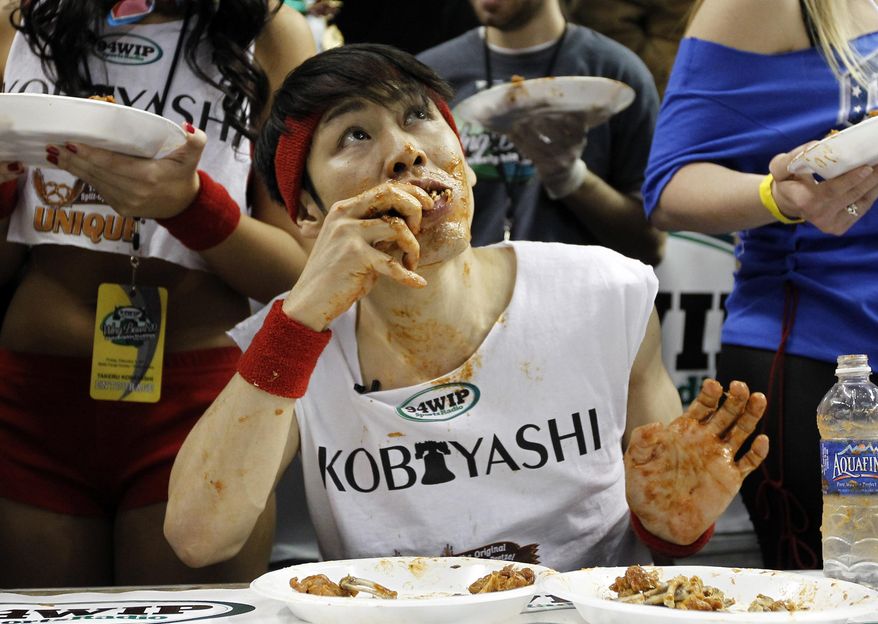 This Feb. 3, 2012, photo shows Japanese competitive eater Takeru Kobayashi eating chicken wings during SportsRadio WIP's Wing Bowl 2012 eating contest in Philadelphia. Kobayashi won by eating 337 wings. Kobayashi is the subject of an ESPN documentary, "The Good, The Bad, The Hungry," airing on Tuesday, July 2, 2019. (AP Photo/Alex Brandon) **FILE**