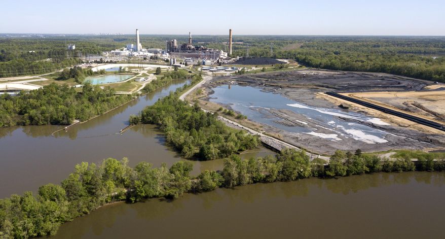 FILE - In this May 1, 2018 file photo the Richmond city skyline can be seen on the horizon behind the coal ash ponds along the James River near Dominion Energy's Chesterfield Power Station in Chester, Va. U.S. EPA officials said Tuesday, July 2, 2019, that modern industry practices and recently-enacted regulations are sufficient to shield taxpayers from potential cleanup costs. (AP Photo/Steve Helber, File)