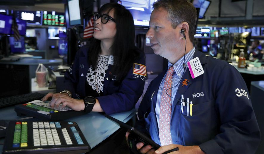 FILE - In this July 1, 2019, file photo specialist Erica Fredricks and trader Robert Charmak work on on the floor of the New York Stock Exchange. The U.S. stock market opens at 9:30 a.m. EDT on Tuesday, July 2. (AP Photo/Richard Drew, File)