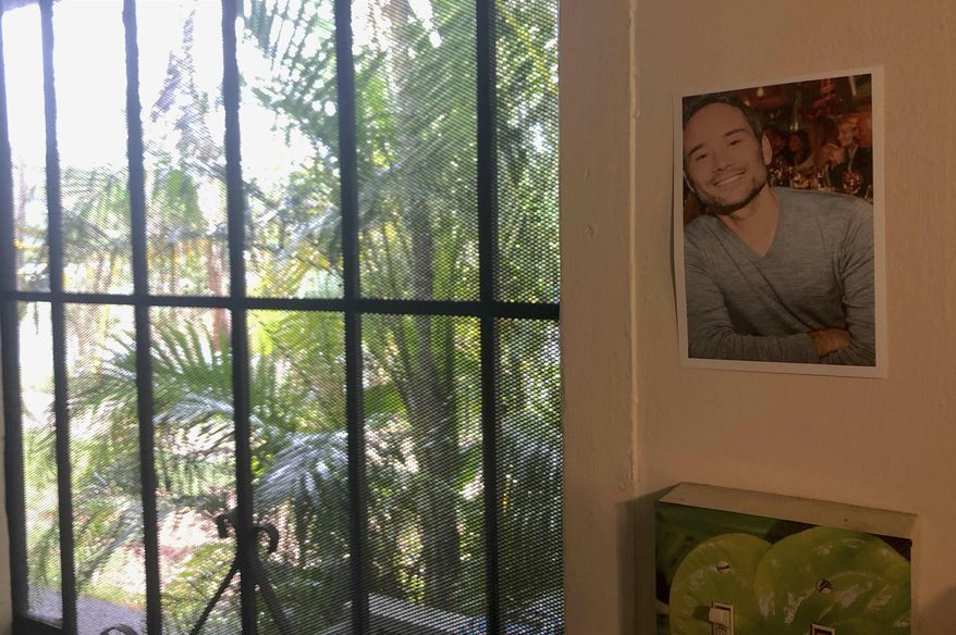 In this Friday, June 28, 2019 photo, a photograph of pilot Jerome Renck hangs next to the door of his apartment in Waialua, Hawaii. The Honolulu Medical Examiner has identified the last two victims of a deadly plane crash on Oahu's North Shore that killed 11 people. In a release Tuesday, July 2, 2019, officials identified the victims as 42-year-old Jerome Renck and 48-year-old James Lisenbee, both of Hawaii. (AP Photo/Caleb Jones)