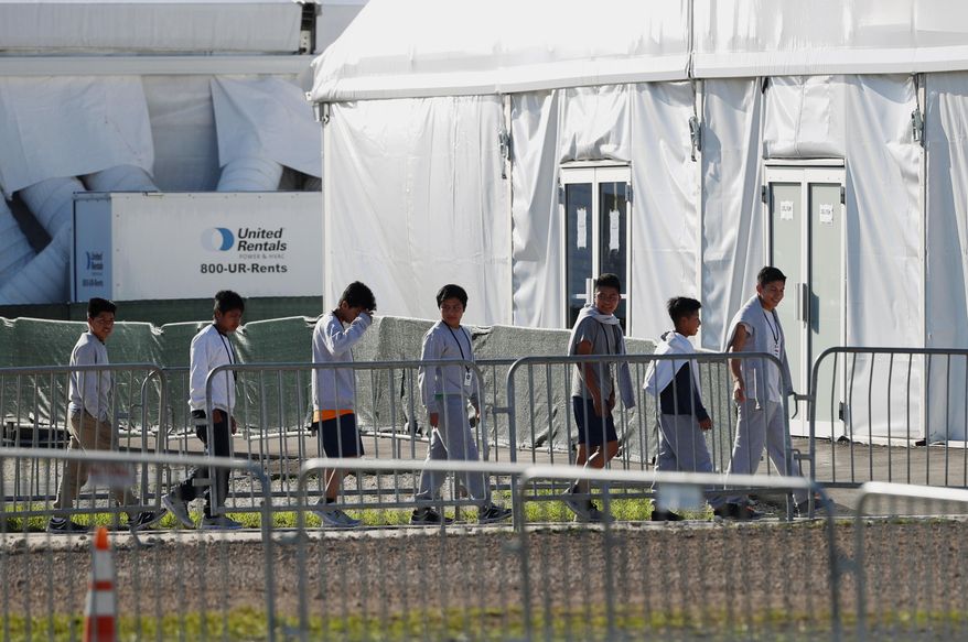 FILE - In this Feb. 19, 2019 file photo, youngsters line up to enter a tent at the Homestead Temporary Shelter for Unaccompanied Children in Homestead, Fla. Advocates for immigrant children are suing to block the Trump administration from enforcing a new policy that they say would erode legal protections for thousands of unaccompanied children seeking asylum in the U.S. (AP Photo/Wilfredo Lee, File)