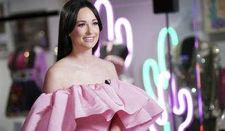 This July 1, 2019 photo shows country singer Kacey Musgraves posing in front of her new exhibit at the Country Music Hall of Fame and Museum in Nashville, Tenn. The exhibit opens Tuesday and runs through June 2020. (Photo by Donn Jones/Invision/AP)