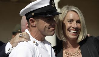 Navy Special Operations Chief Edward Gallagher, left, and his wife, Andrea Gallagher smile, after leaving a military court on Naval Base San Diego, Tuesday, July 2, 2019, in San Diego. A military jury acquitted the decorated Navy SEAL Tuesday of murder in the killing of a wounded Islamic State captive under his care in Iraq in 2017. (AP Photo/Gregory Bull)