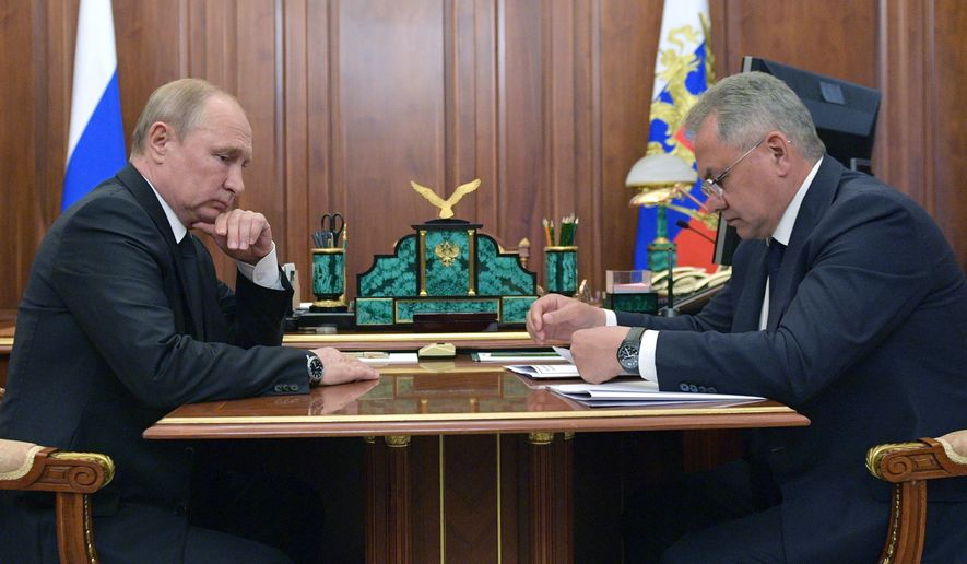Russian President Vladimir Putin listens to Russian Defense Minister Sergei Shoigu during their meeting in the Kremlin in Moscow, Russia, Tuesday, July 2, 2019. A fire on one of the Russian navy's deep-sea submersibles killed 14 sailors, the Russian Defense Ministry said Tuesday without giving the cause of the blaze or saying if there were survivors. (Alexei Druzhinin, Sputnik, Kremlin Pool Photo via AP)
