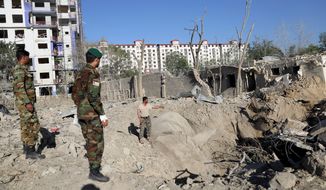 Afghan soldiers stand amid the aftermath of Monday&#39;s attack in Kabul, Afghanistan, Tuesday, July 2, 2019. The Taliban set off a powerful bomb in downtown Kabul on Monday, killing a several people and wounding more than a hundred, and sending a cloud of smoke billowing over the Afghan capital.  (AP Photo/Rahmat Gul)