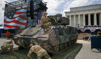 An Army soldier hops out of a Bradley Fighting Vehicle after moving it into place by the Lincoln Memorial, Wednesday, July 3, 2019, in Washington, ahead of planned Fourth of July festivities with President Donald Trump. (AP Photo/Jacquelyn Martin)