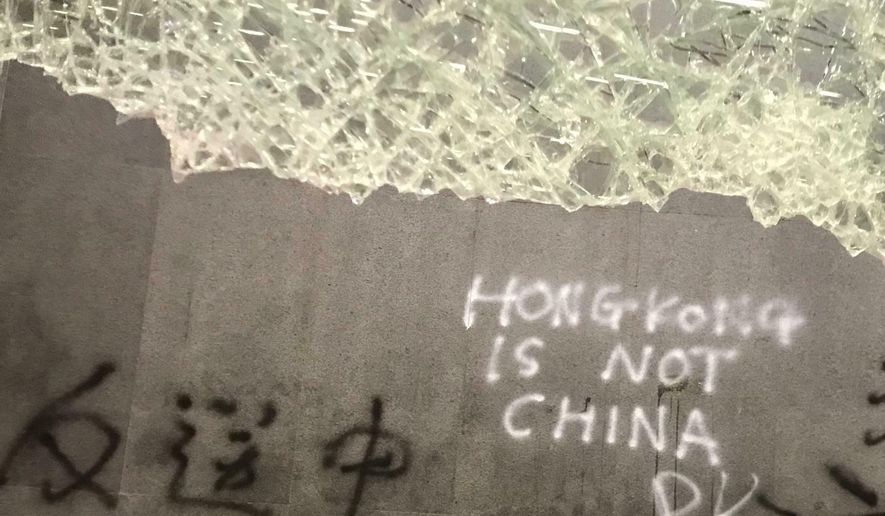 Damage to the Legislative Council following a break-in by protesters is seen during a media tour, Wednesday, July 3, 2019, in Hong Kong. Chinese characters read "No Extradition to China." (AP Photo/Johnson Lai)