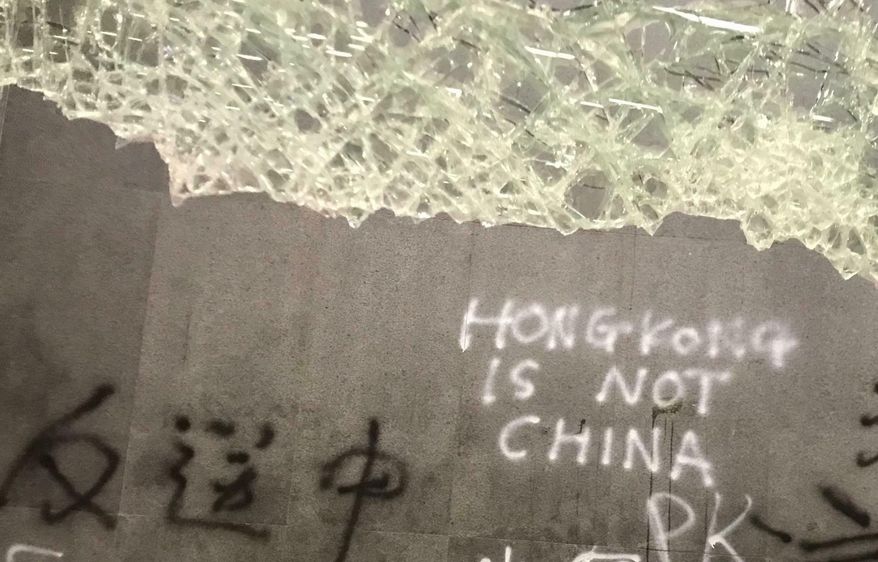 Damage to the Legislative Council following a break-in by protesters is seen during a media tour, Wednesday, July 3, 2019, in Hong Kong. Chinese characters read "No Extradition to China." (AP Photo/Johnson Lai)