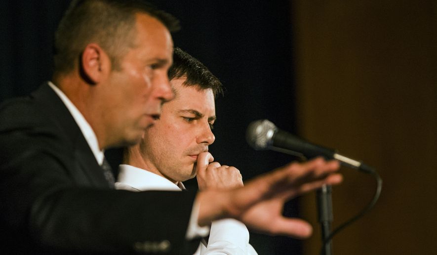 FILE - In this June 23, 2019 file photo, South Bend Police Chief Scott Ruszkowski, left, speaks as Democratic presidential candidate and South Bend Mayor Pete Buttigieg listens during a town hall community meeting, in South Bend, Ind. A white police officer who fatally shot a black man in the Indiana city where Buttigieg is mayor says he and his family never expected to be &amp;quot;thrown into the middle of a Presidential campaign.&amp;quot; Eric Logan&#39;s fatal shooting by South Bend Sgt. Ryan O&#39;Neill forced Buttigieg, who&#39;s seeking the Democratic presidential nomination, off the campaign trail for days. (Robert Franklin/South Bend Tribune via AP, File)