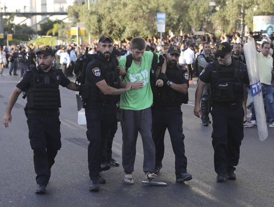 Police arrest a a man during a protest in Tel Aviv, Israel, Wednesday, July 3, 2019. Israeli police were bracing for another day of violent protests Wednesday after community activists called for renewed street demonstrations in response to the killing of an Ethiopian-Israeli teen by an off-duty police officer. (AP Photo/Oded Balilty)