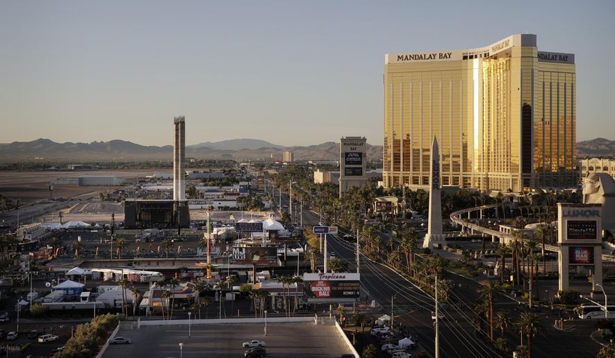 FILE - This Oct. 3, 2017, file photo shows the Mandalay Bay resort and casino, right, overlooking an outdoor festival grounds across the street, left, in Las Vegas. A veteran Las Vegas police officer who froze in the hallway of the casino-hotel as a gunman carried out the deadliest mass shooting in modern U.S. history has been fired from the force, police said. Officer Cordell Hendrex was fired from the Las Vegas Metropolitan Police Department on March 20, 2019, police spokesman Officer Larry Hadfield said late Tuesday, July 2. (AP Photo/John Locher, File)