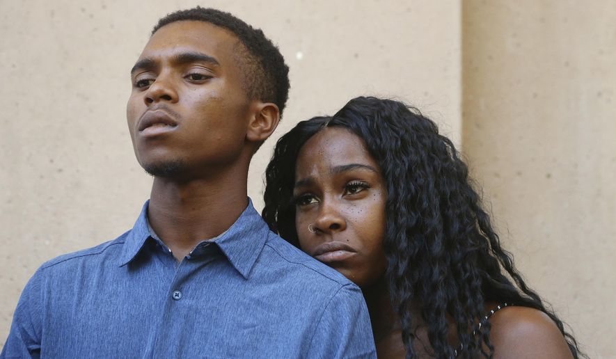 FILE - In a Monday, June 17, 2019 file photo, Dravon Ames, left, and Iesha Harper pause as they listen to a question during a news conference at Phoenix City Hall, in Phoenix. Phoenix leaders said Wednesday, July 3, 2019 that the city charter prevented them from acting on a formal request to fire police officers caught on video pointing guns and hurling obscenities at the black couple. (AP Photo/Ross D. Franklin, File)