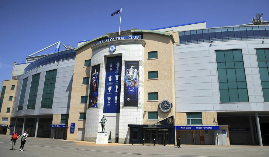 People walks past Stamford Bridge, London, Friday June 28, 2019. Frank Lampard has returned to Chelsea as the club’s 12th manager in 16 years under Roman Abramovich’s ownership. The former Chelsea midfielder has left second-tier club Derby, where he spent he came close to securing promotion to the Premier League in his first season in management. (Adam Davy/PA via AP)