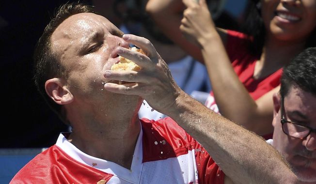 Joey Chestnut stuffs his mouth with hot dogs during the men&#x27;s competition of Nathan&#x27;s Famous July Fourth hot dog eating contest, Thursday, July 4, 2019, in New York&#x27;s Coney Island. (AP Photo/Sarah Stier)