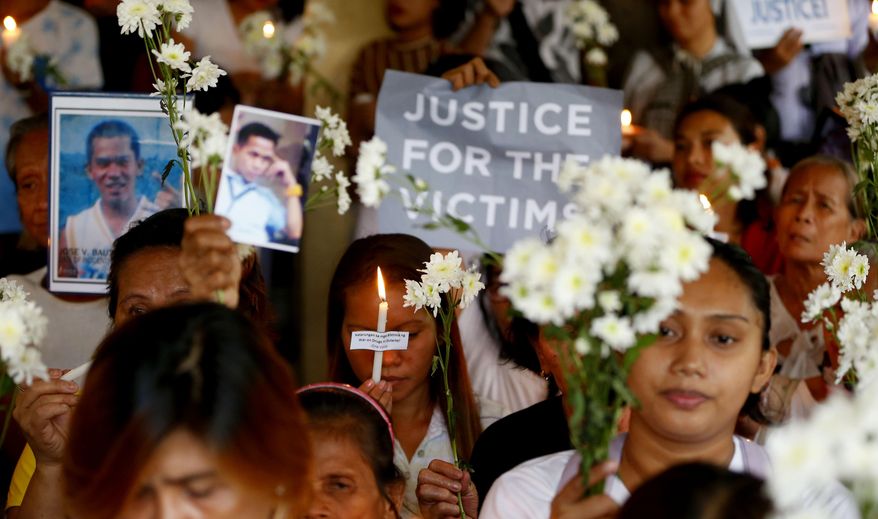 FILE - In this March 17, 2019, file photo, relatives of victims in President Rodrigo Duterte's so-called war on drugs hold a memorial for their loved ones at a church in Manila, Philippines. On Thursday, July 4, 2019, the Commission on Human Rights has condemned the killing of a three-year-old girl in a crossfire in a Philippine police raid in which her father, a drug suspect, was gunned down along with another civilian and a police officer. (AP Photo/Bullit Marquez, File)