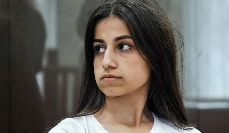 In this photo taken on Wednesday, June 26, 2019, Angelina Khachaturyan attends hearings in a court room in Moscow, Russia. Three Khachaturyan sisters, now aged 18, 19 and 20, face charges for the premeditated murder of their father who allegedly abused them for years, could land them in prison for up to 20-years, but the case has provoked outrage in Russia and calls to stop the court case. (Alexander Avilov, Moscow News Agency photo via AP)