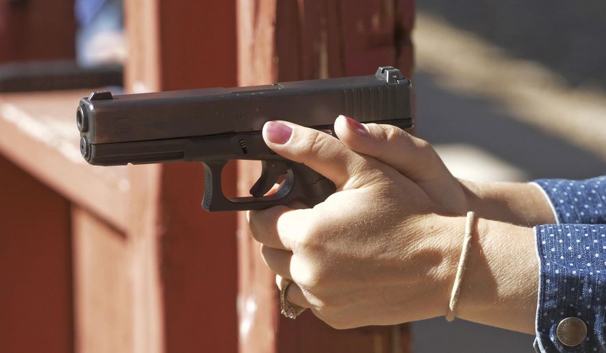 In this Saturday, June 29, 2019, photo, Cindy Bullock, Timpanogos Academy secretary, participates in shooting drills at the Utah County Sheriff's Office shooting range during the teacher's academy training, in Spanish Fork Canyon, Utah. About 30 teachers in Utah are spending their summer learning how to stuff wounds and shoot guns as part of a training held by police to prepare educators for an active shooter scenario in their schools. A judge has approved a $13 million settlement in a lawsuit over an unannounced active shooter drill at a Michigan psychiatric hospital for children, an event that terrified kids and staff and caused them to scramble for cover, text family and urgently call 911. (AP Photo/ Rick Bowmer)