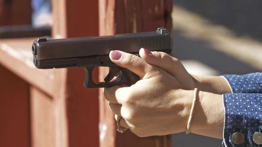 In this Saturday, June 29, 2019, photo, Cindy Bullock, Timpanogos Academy secretary, participates in shooting drills at the Utah County Sheriff's Office shooting range during the teacher's academy training, in Spanish Fork Canyon, Utah. About 30 teachers in Utah are spending their summer learning how to stuff wounds and shoot guns as part of a training held by police to prepare educators for an active shooter scenario in their schools. (AP Photo/ Rick Bowmer)