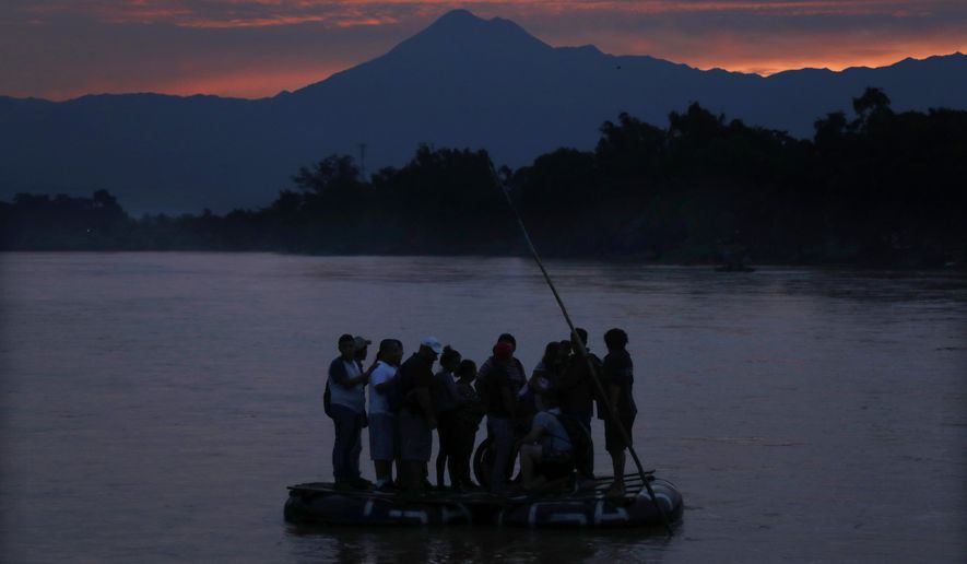 FILE - In this early Monday, June 10, 2019 file photo, Central American migrants stand on a raft to cross the Suchiate River from Guatemala to Mexico, with the Tacana volcano in the background, near Ciudad Hidalgo, Mexico. A record 71 million people were forcibly displaced around the world in 2018, according to a report last month by the United Nations refugee agency, in places as diverse as Turkey, Uganda, Bangladesh and Peru. (AP Photo/Marco Ugarte)
