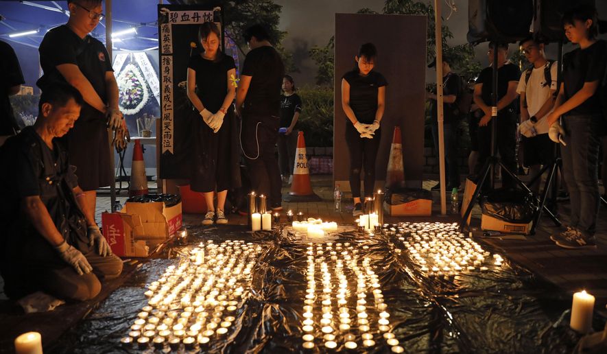 People pay during the one minute silent at a vigil to mourn the recent suicide of a woman due to the government's policy on the extradition bill in Hong Kong Saturday, July 6, 2019. A vigil is being held in Hong Kong for a woman who fell to her death this week, one of three apparent suicides linked to ongoing protests over fears that freedoms are being eroded in this semi-autonomous Chinese territory. (AP Photo/Vincent Yu)