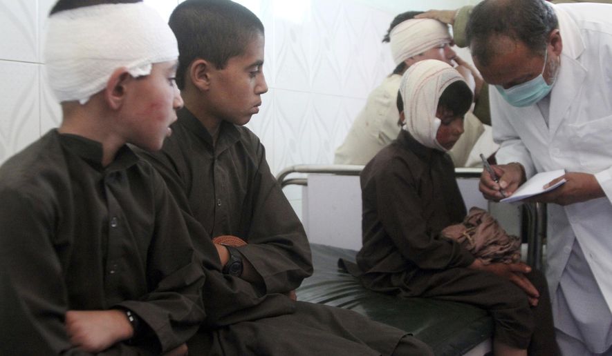 Injured boys receive treatment in a hospital after a car bomb attack in Ghazni province, central Afghanistan, Sunday, July 7, 2019. Afghan officials say a car bomb in central Afghanistan has killed a few people and wounded dozens of people, many of them students attending a nearby school. (AP Photo/Rahmatullah Nikzad)