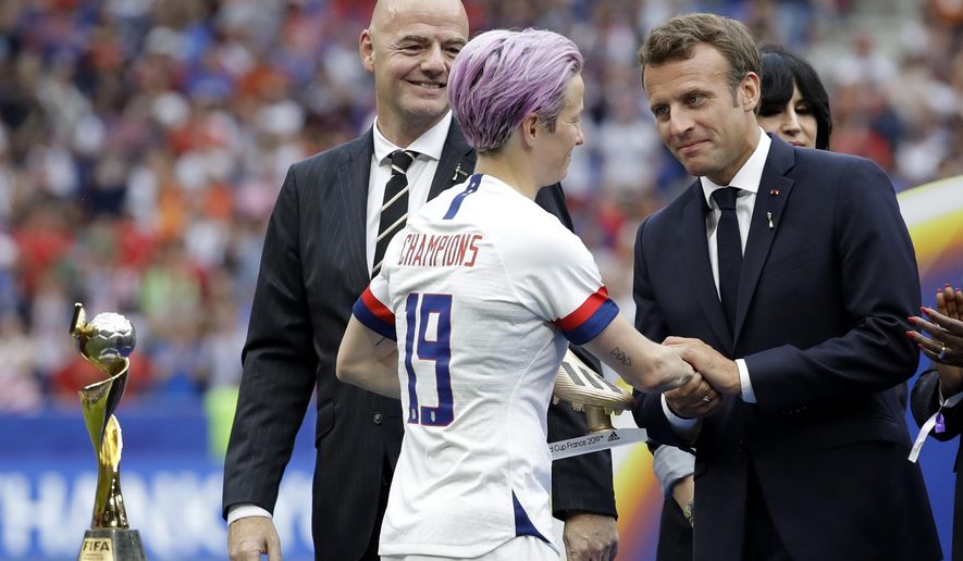 French President Emmanuel Macron, right, and FIFA President Gianni Infantino , left, congratulate to United States' Megan Rapinoe, center, after the Women's World Cup final soccer match between US and The Netherlands at the Stade de Lyon in Decines, outside Lyon, France, Sunday, July 7, 2019. (AP Photo/Alessandra Tarantino)