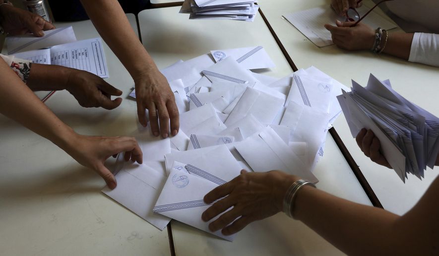 Election representatives count ballots after polling station closed in Athens, on Sunday, July 7, 2019. Exit polls in Greece's general election indicate conservative opposition leader Kyriakos Mitsotakis has won a comfortable victory over left-wing Prime Minsiter Alexis Tsipras. (AP Photo/Yorgos Karahalis)